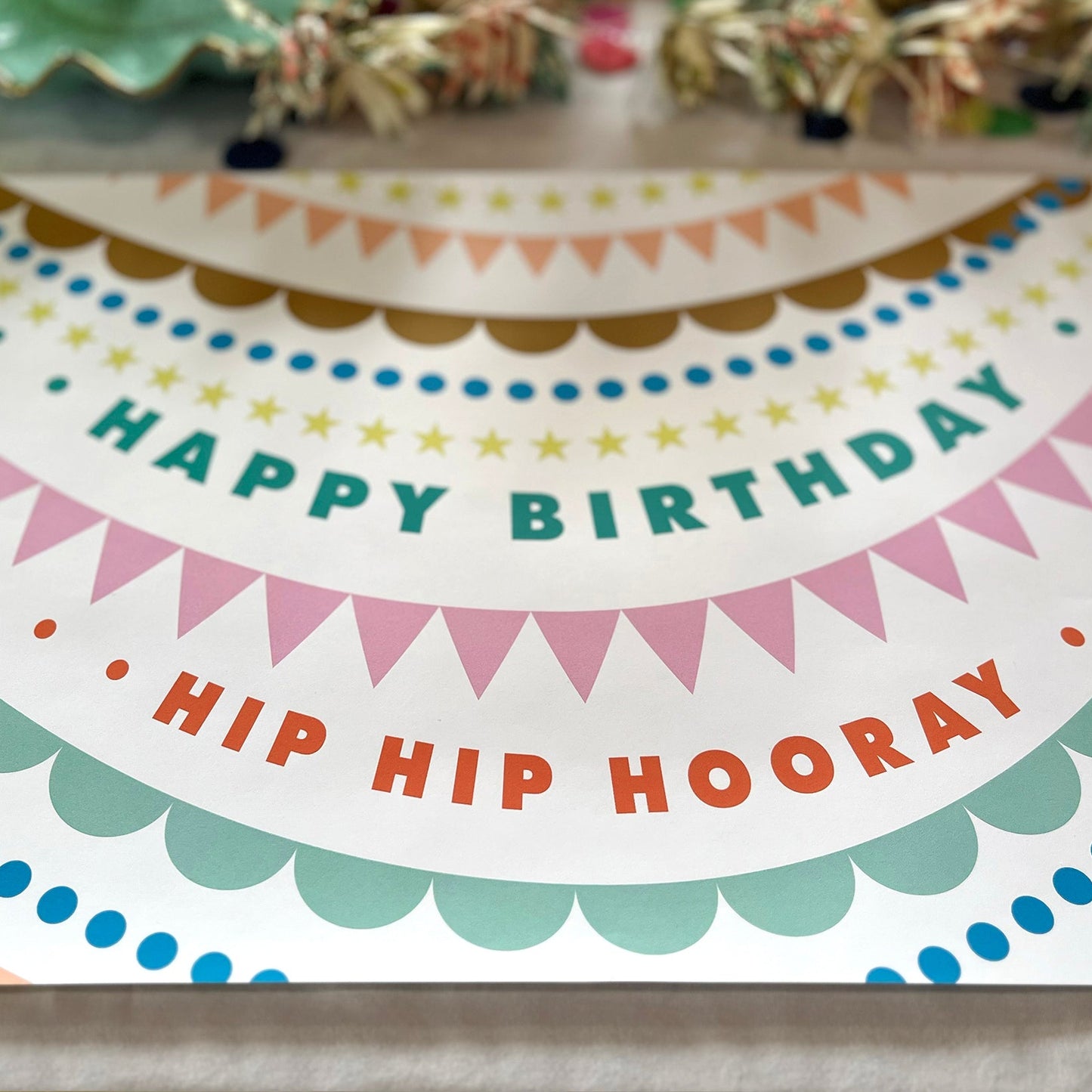 Colorful birthday paper placemat with 'Happy Birthday, Hip Hip Hooray' text.