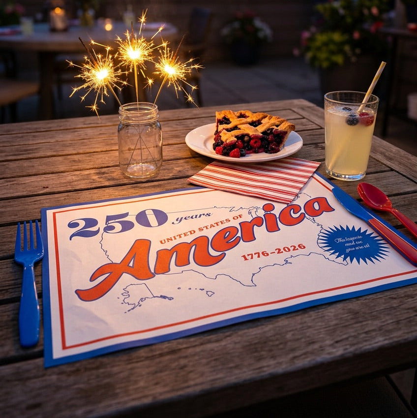 Outdoor table setting with pie, drink, and sparklers during fireworks display.