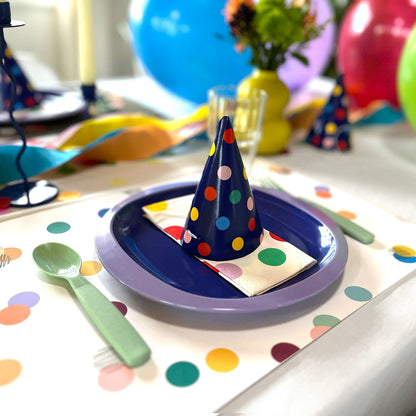 Children's party table setting with colorful plates, napkins, and balloons.