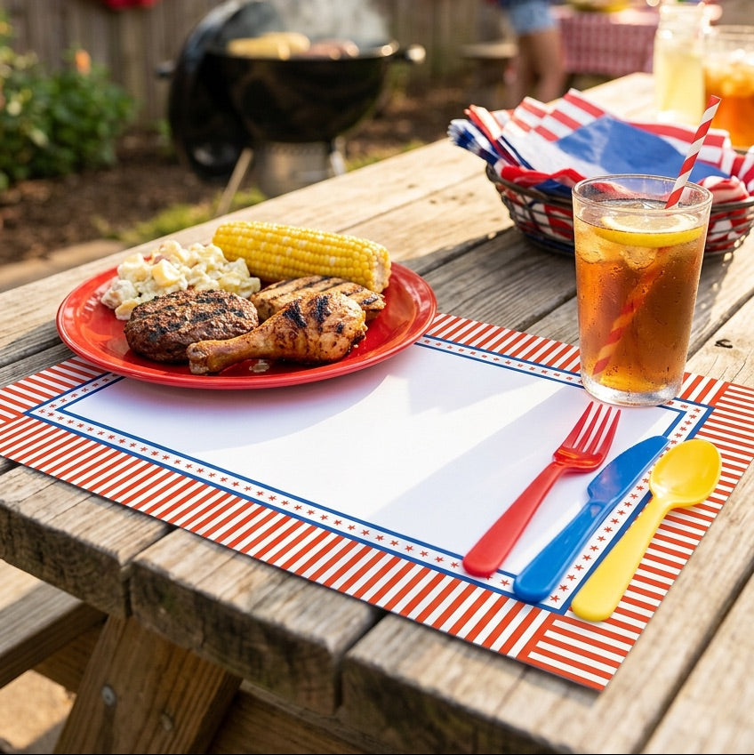 Outdoor picnic setting with food and drinks on a wooden table, patriotic decorations in the background.