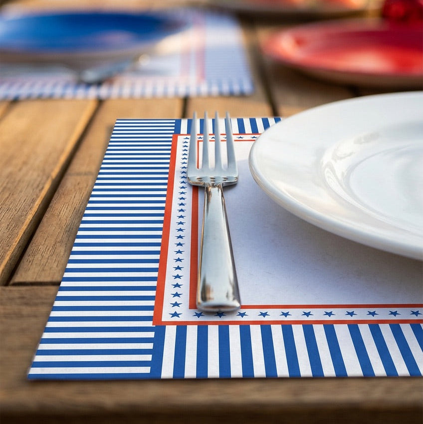 Dining table setting with a striped paper placemat, white plate, and silver fork.