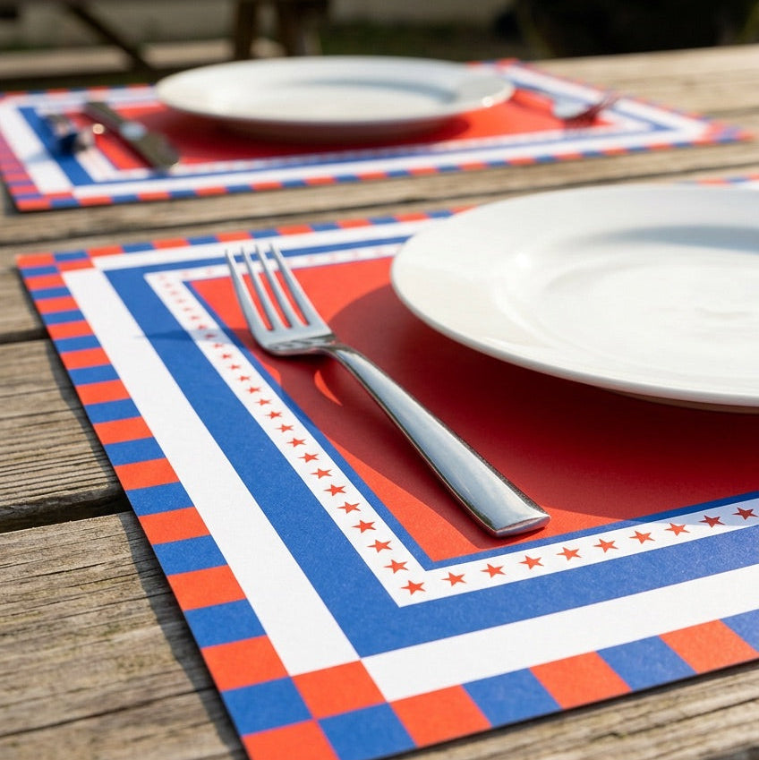 Placemats with red, white, and blue pattern on a wooden table.