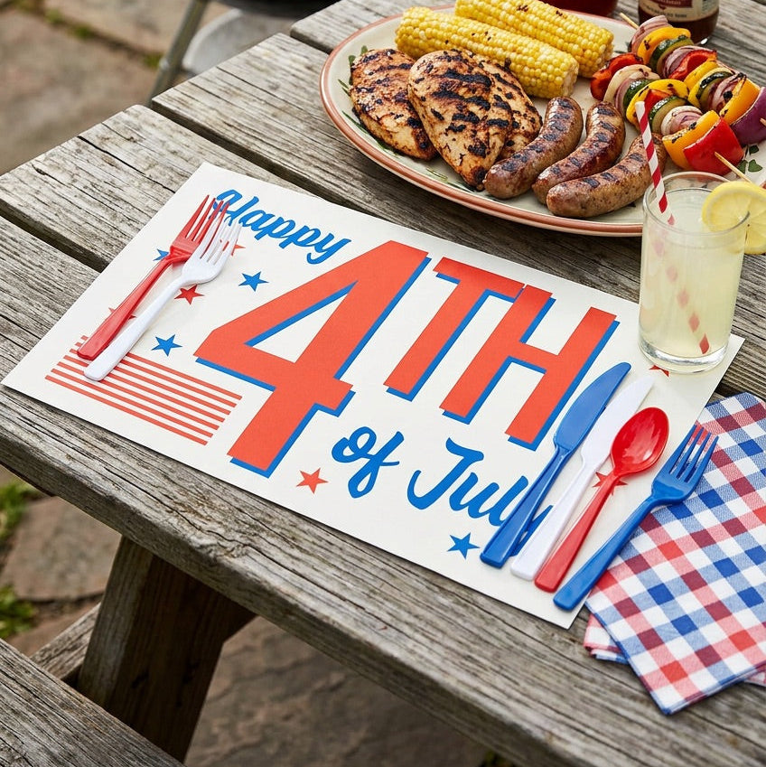 Outdoor setting with a grill, food, and 'Happy 4th of July' paper placemat.