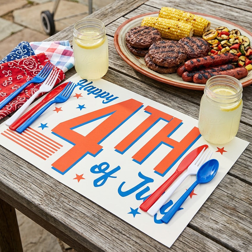 Outdoor setting with a 'Happy 4th of July' paper placemat, grilled food, and lemonade.