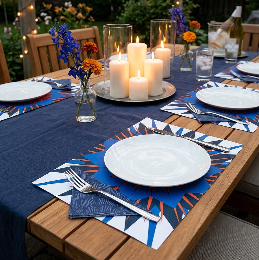 Outdoor table setting with candles, flowers, and patriotic paper placemats.
