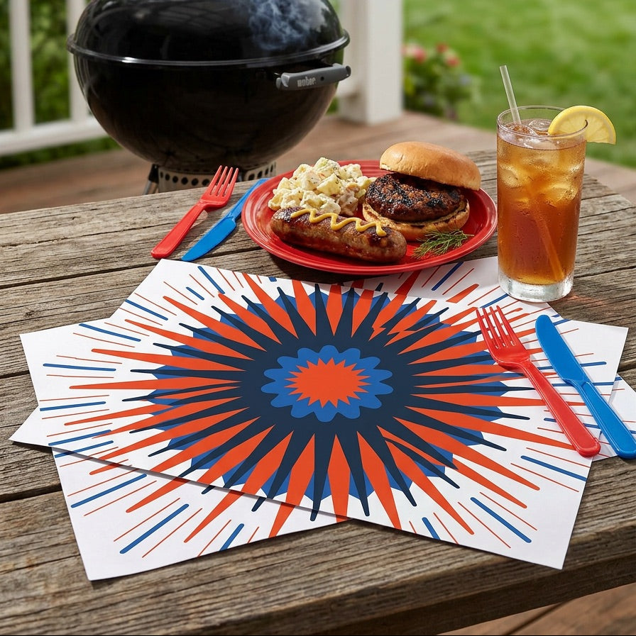 Outdoor setting with a grill, food, and drink on a table with decorative paper placemats.