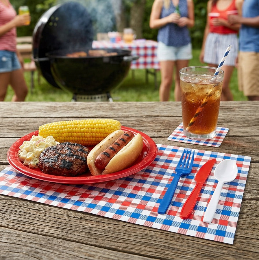Outdoor gathering with a grill, food on a plate, and paper placemat with people in the background.