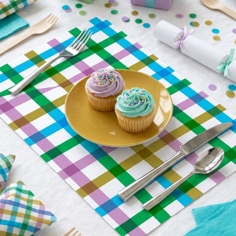 Colorful table setting with checkered paper placemats, cupcakes, and decorative items.