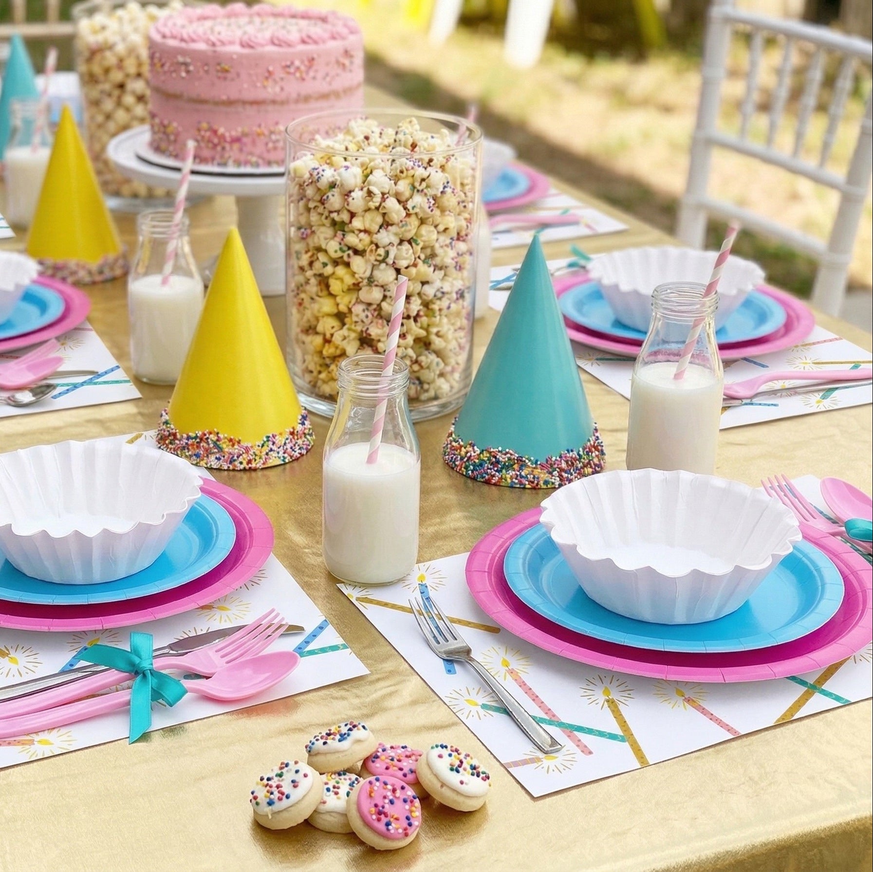 Children's birthday party table setting with colorful plates, cups, and decorations.