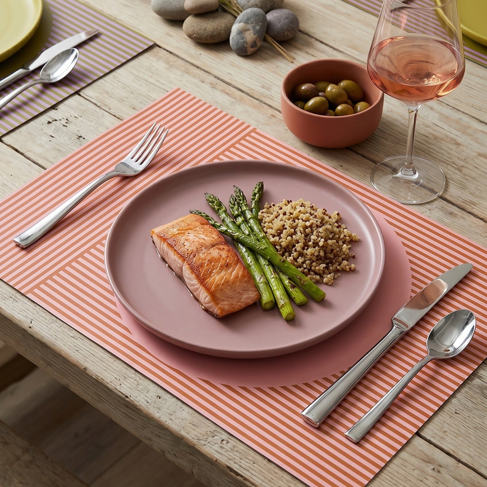Modern striped paper placemat on a wood table set up for a modern dinner party.