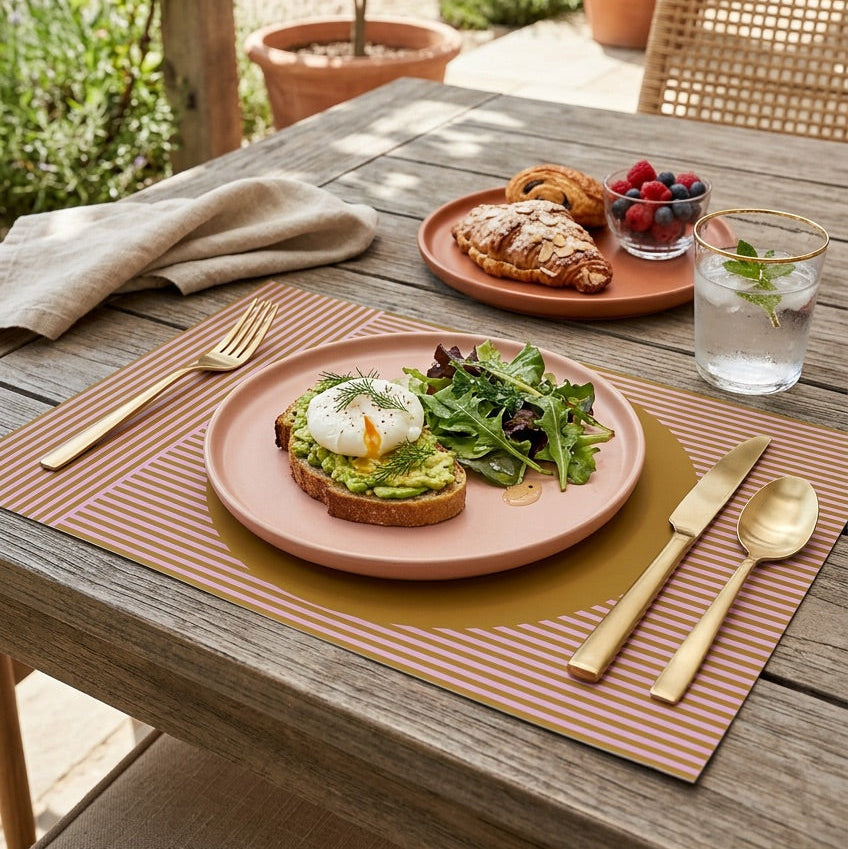Modern striped paper placemat on a wood table set up for an outdoor brunch. 