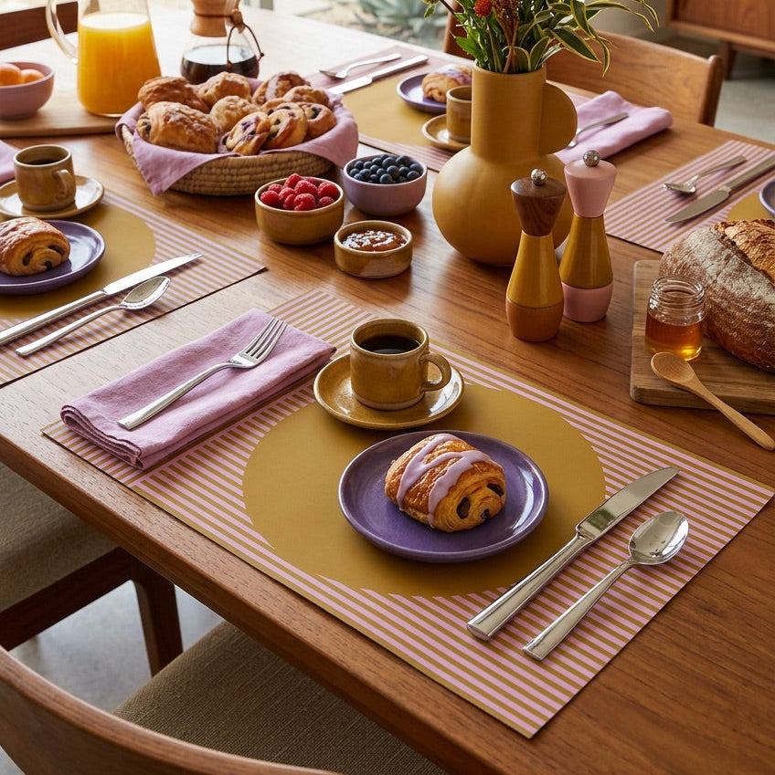 Modern striped paper placemat on a wood table set up for a modern breakfast.