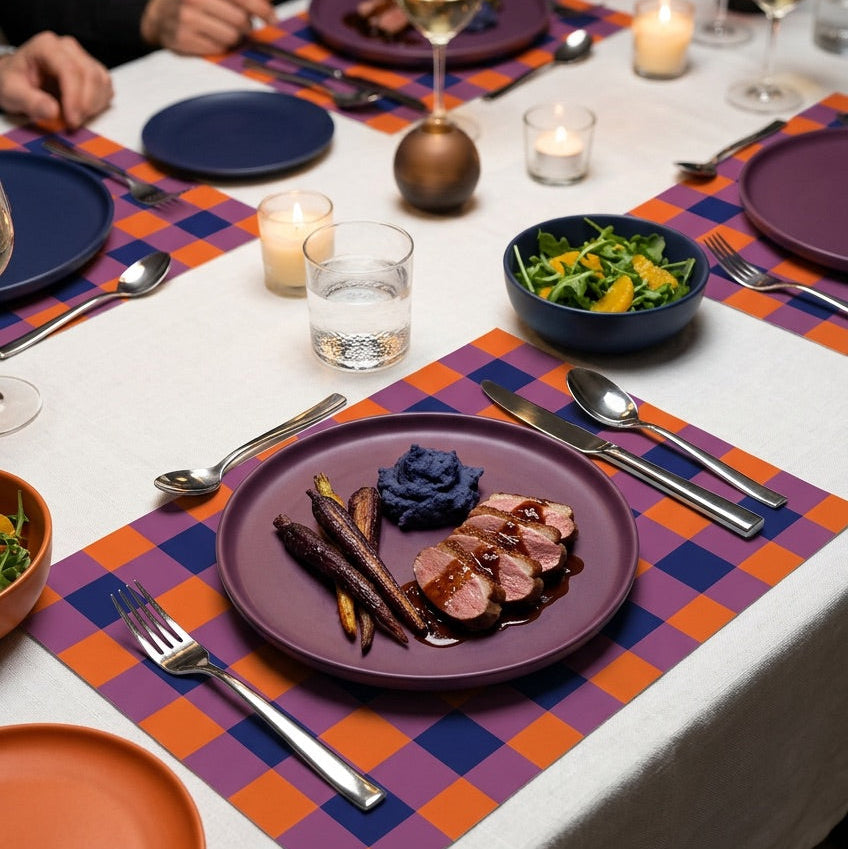 Plaid paper placemat on a modern table set for dinner. 