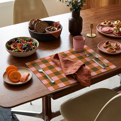 Plaid paper placemat on a modern table set for dinner. 