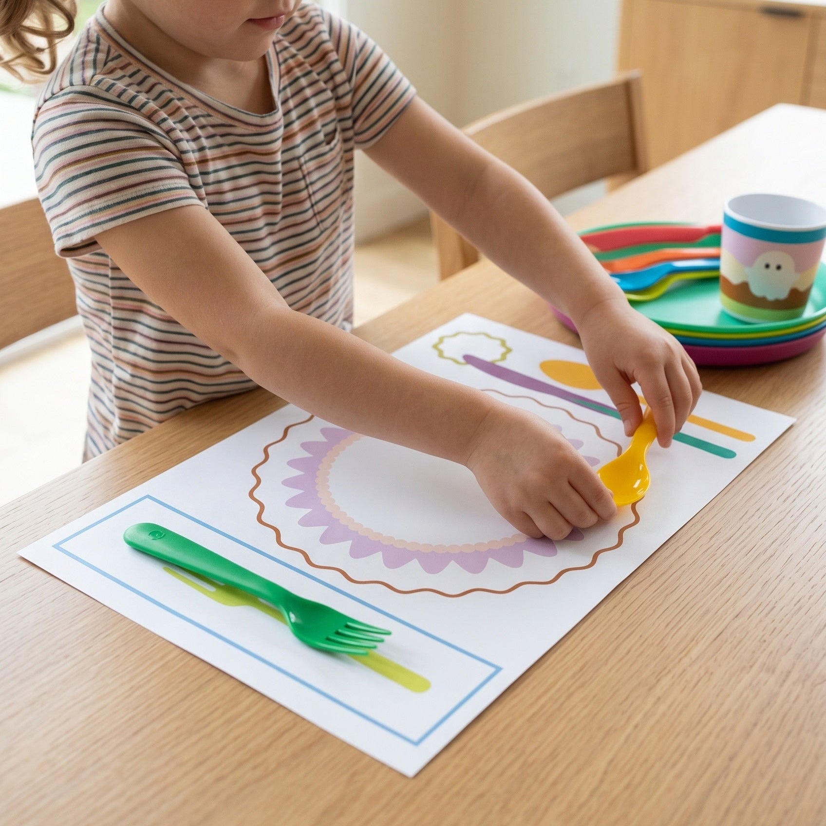 Child playing with utensils on a placemat at a table