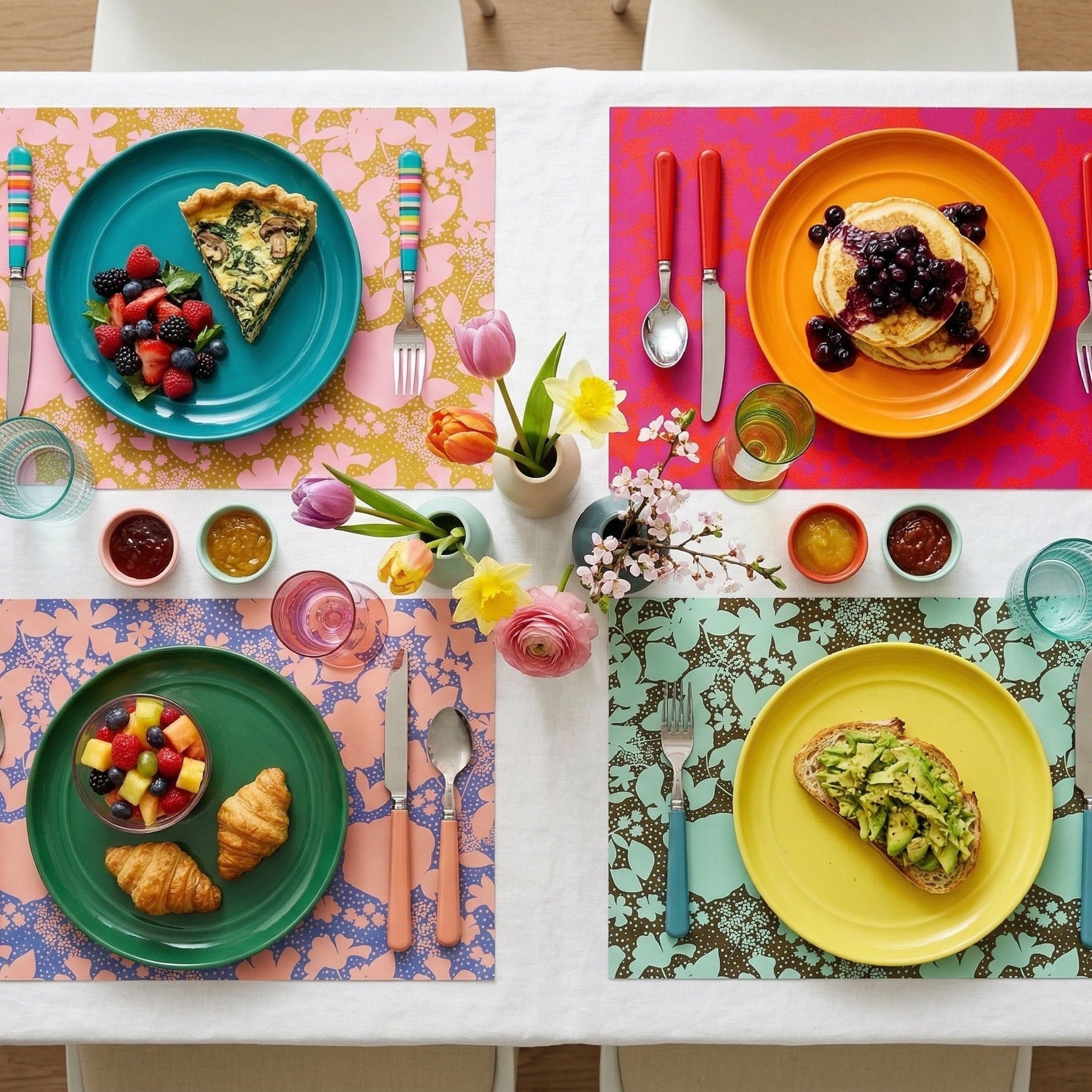 Set of 4 floral paper placemats on a table with breakfast foods. 