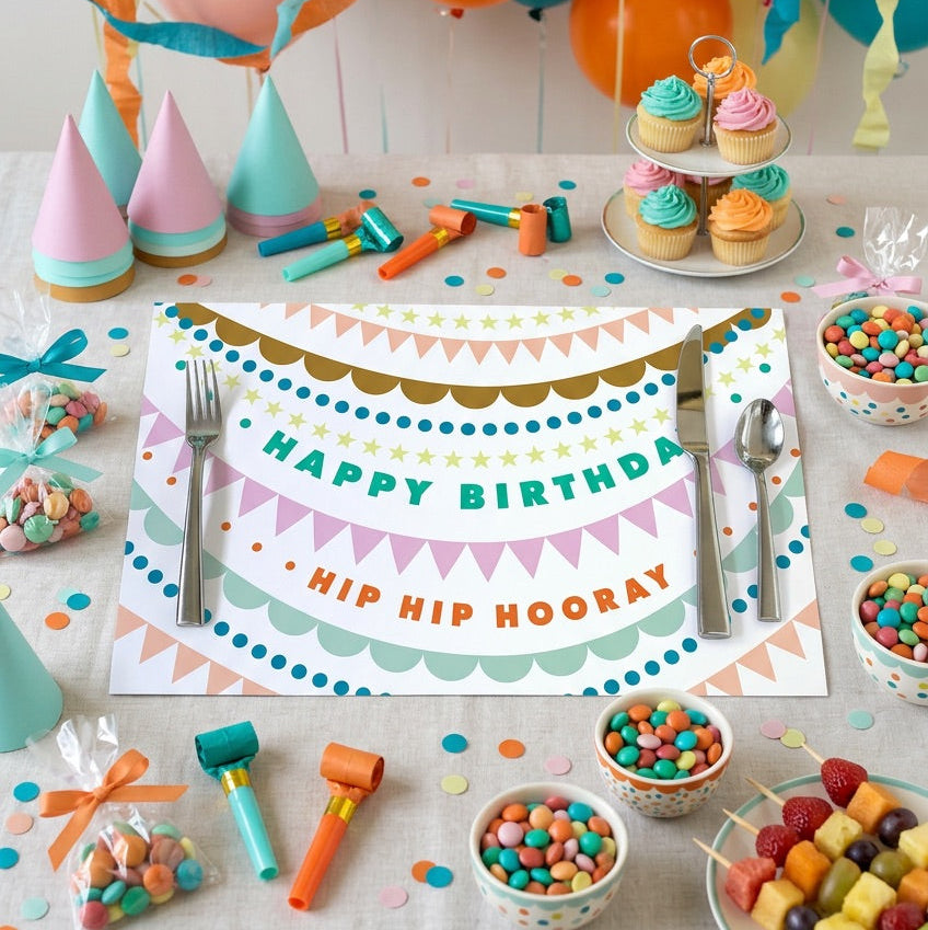 Happy Birthday paper placemat with a birthday cake and balloons. 