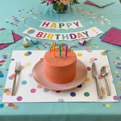 Confetti paper placemats with confetti on the table set for a birthday party. 