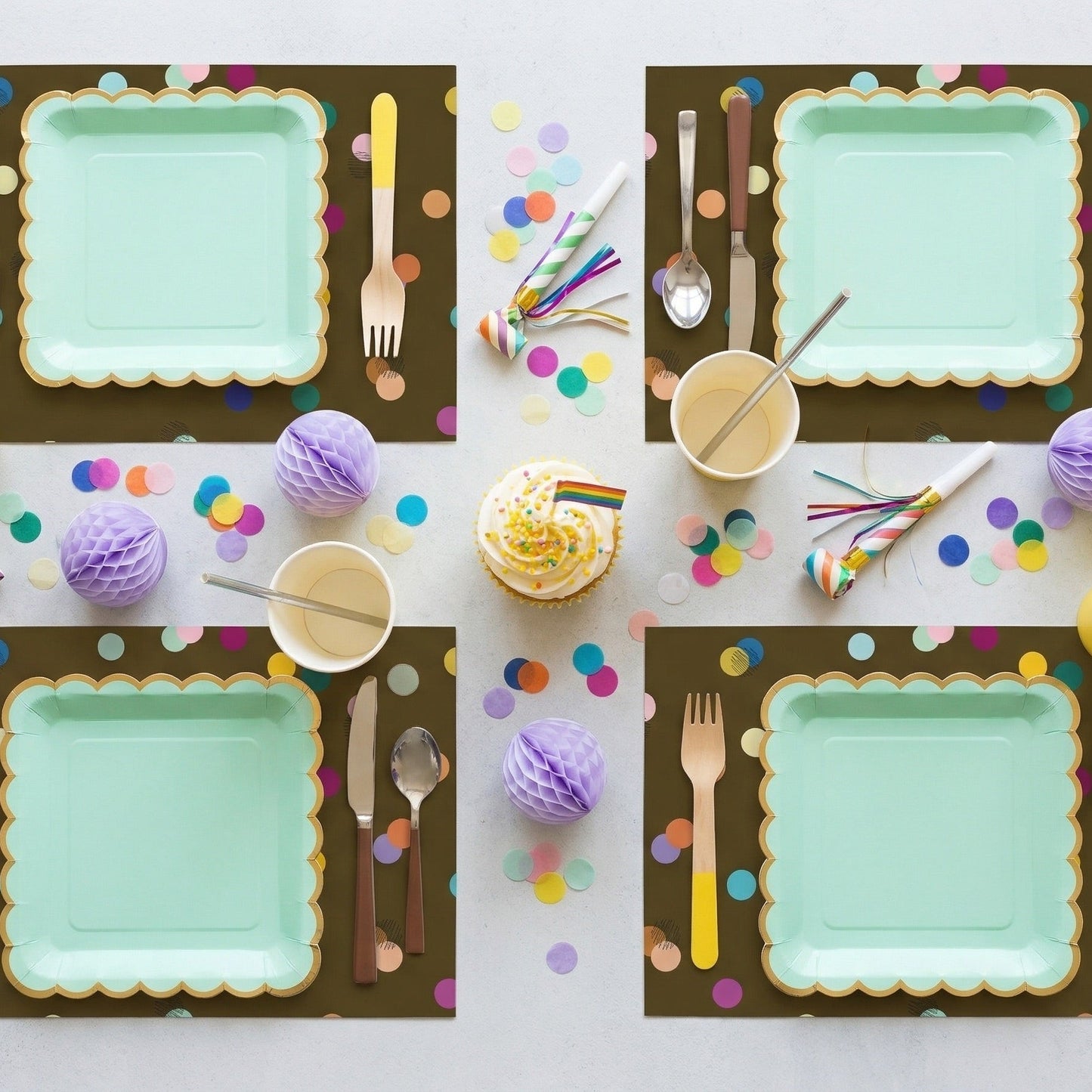 Confetti paper placemats with confetti on the table set for a birthday party. 