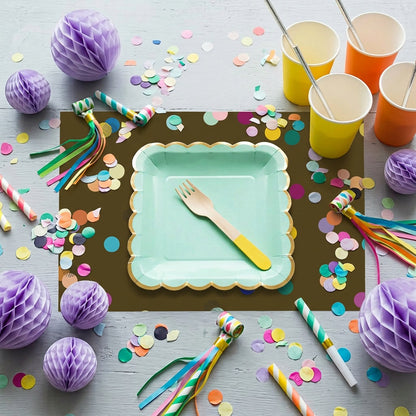 Confetti paper placemats with confetti on the table set for a birthday party. 