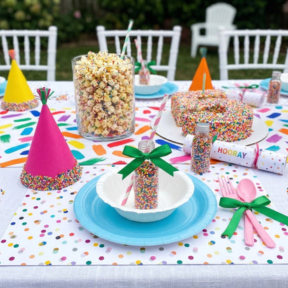 Confetti paper placemats with confetti on the table set for a birthday party. 