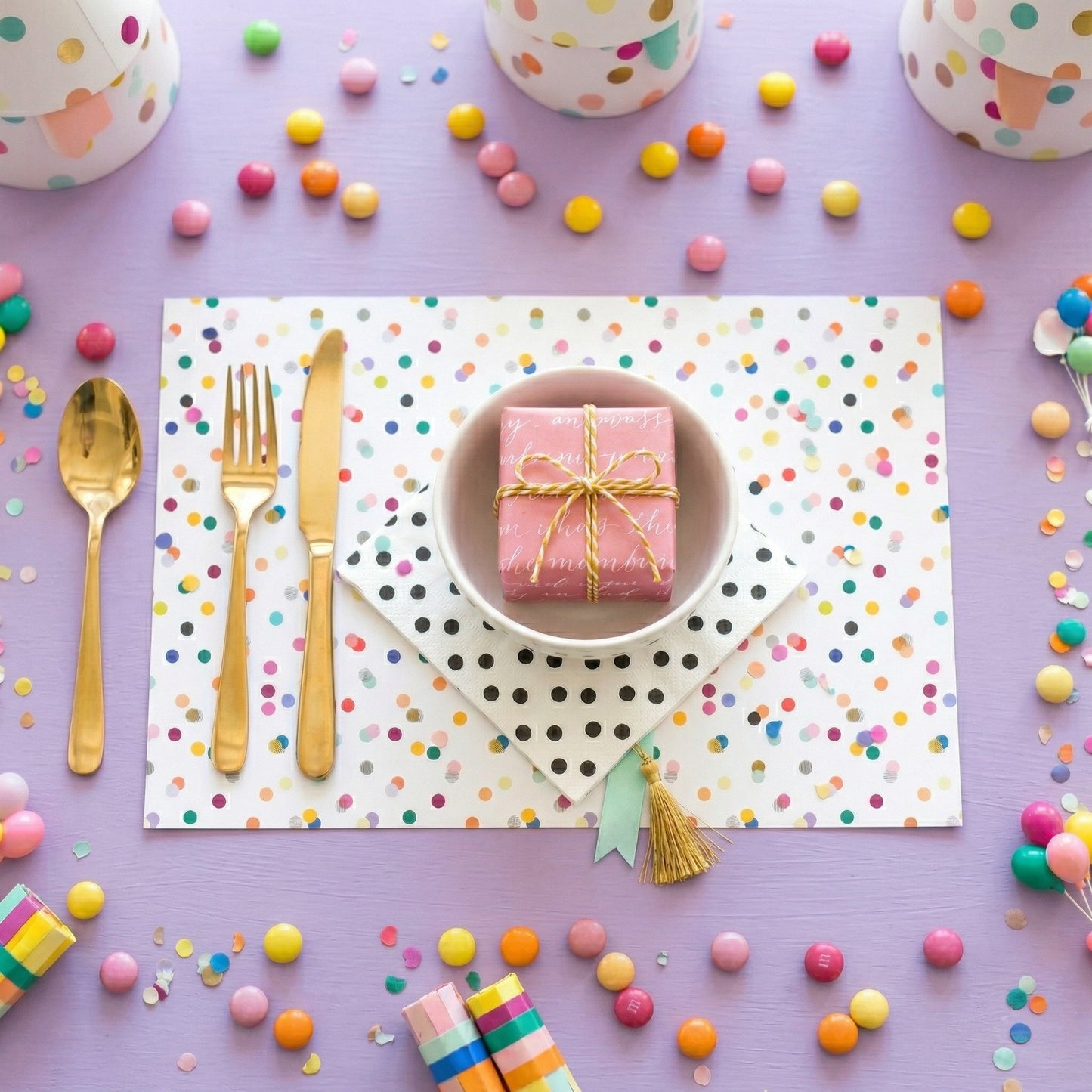 Confetti paper placemats with confetti on the table set for a birthday party. 