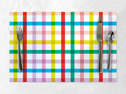 Colorful plaid paper placemat with cutlery on a white background