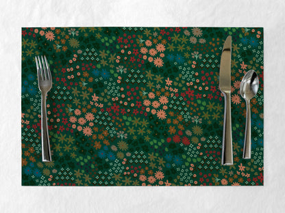 Floral patterned paper placemat with silverware on a white background