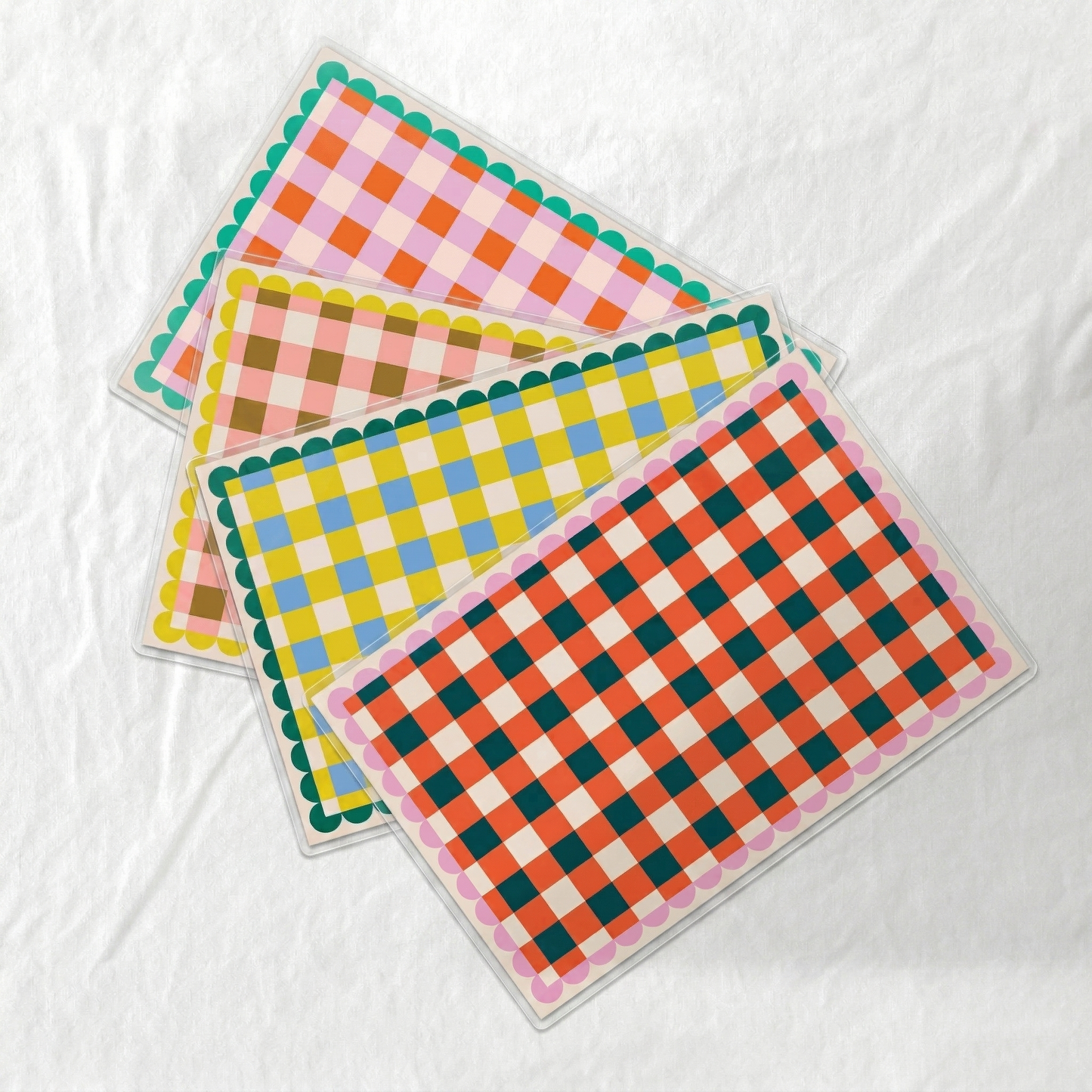 Set of colorful checkered paper laminated placemats on a white background