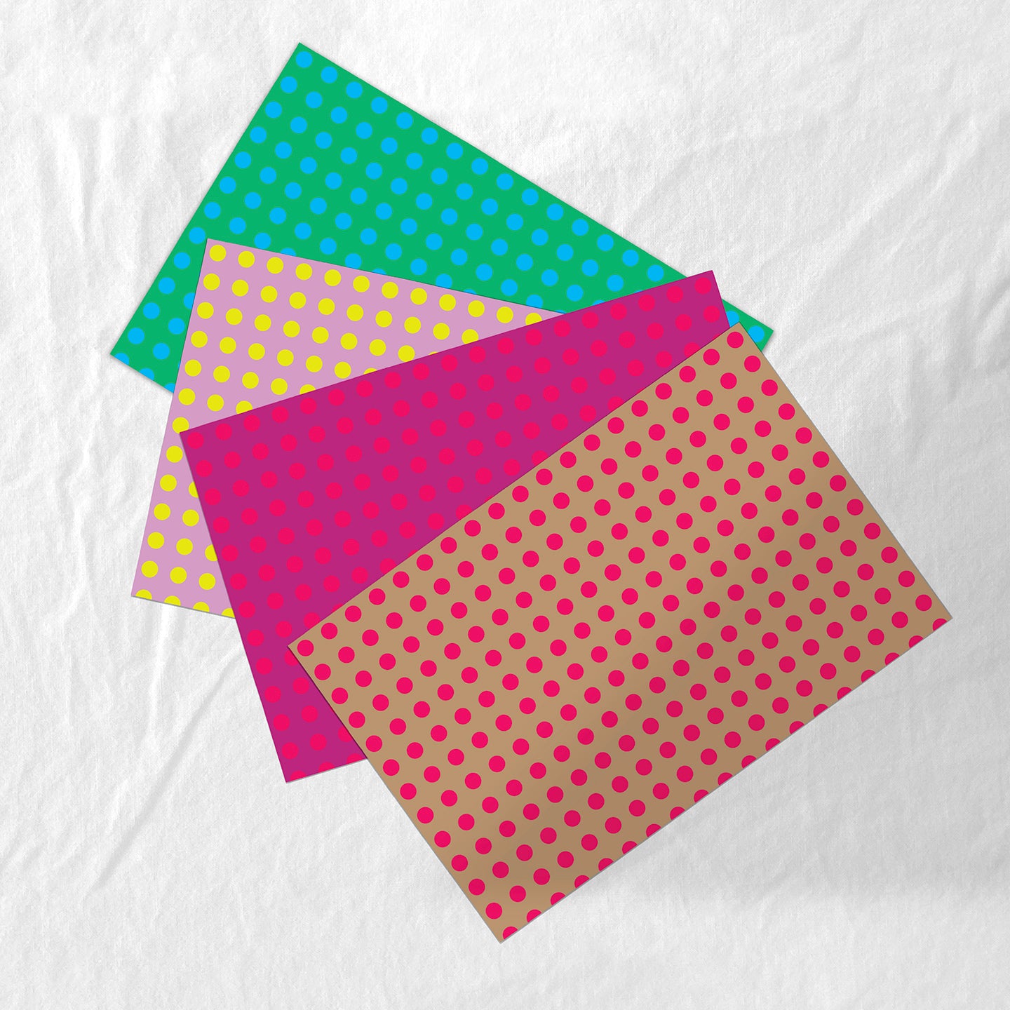 Four sheets of polka dot paper placemats in different colors on a white background