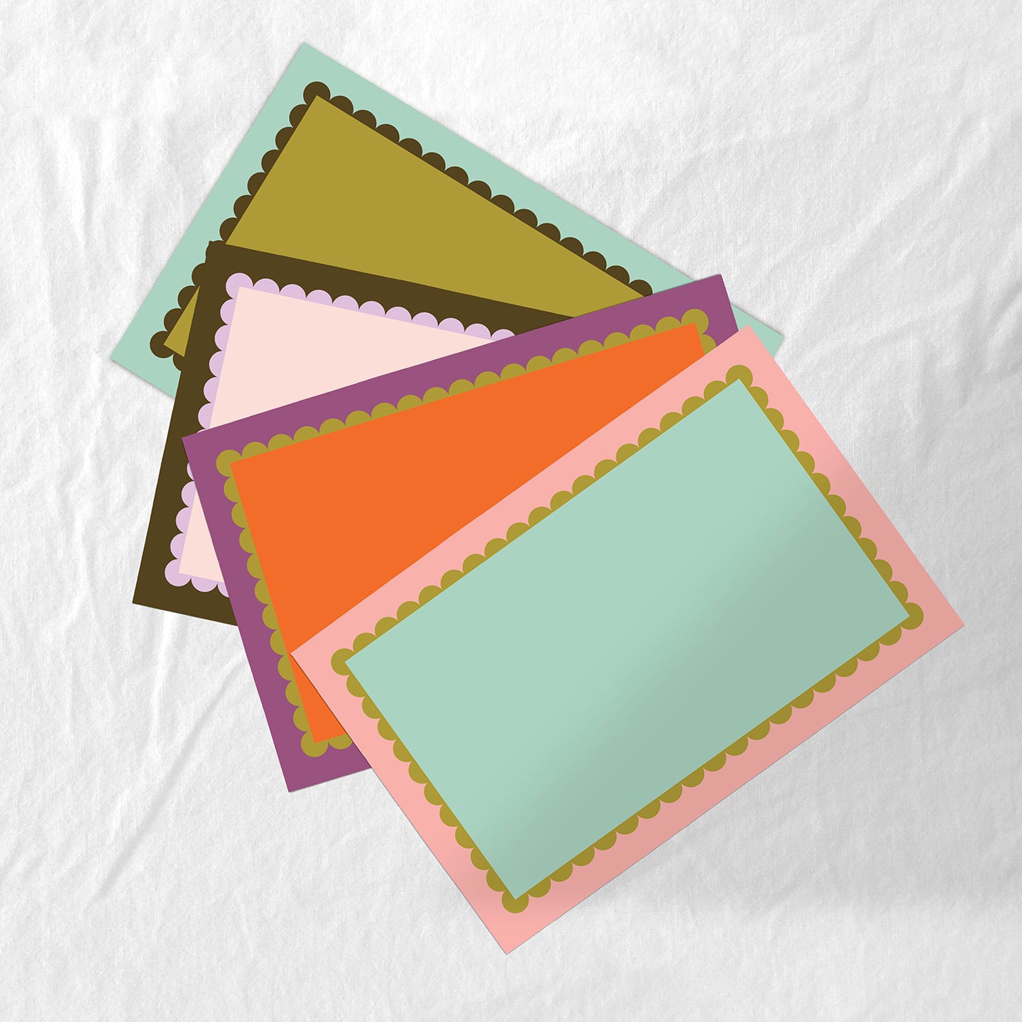 Colorful paper placemat set with scallop frame design. 