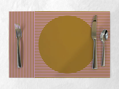 Placemat with a gold circle, fork, knife, and spoon on a striped pink and brown background.