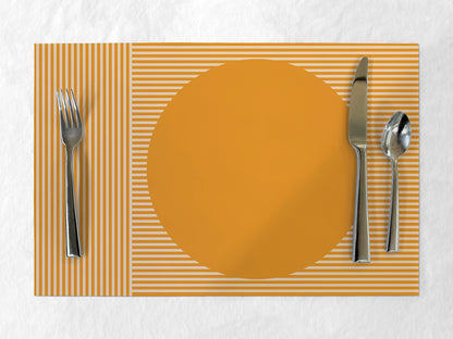 Placemat with a round orange center, fork, knife, and spoon on a striped background