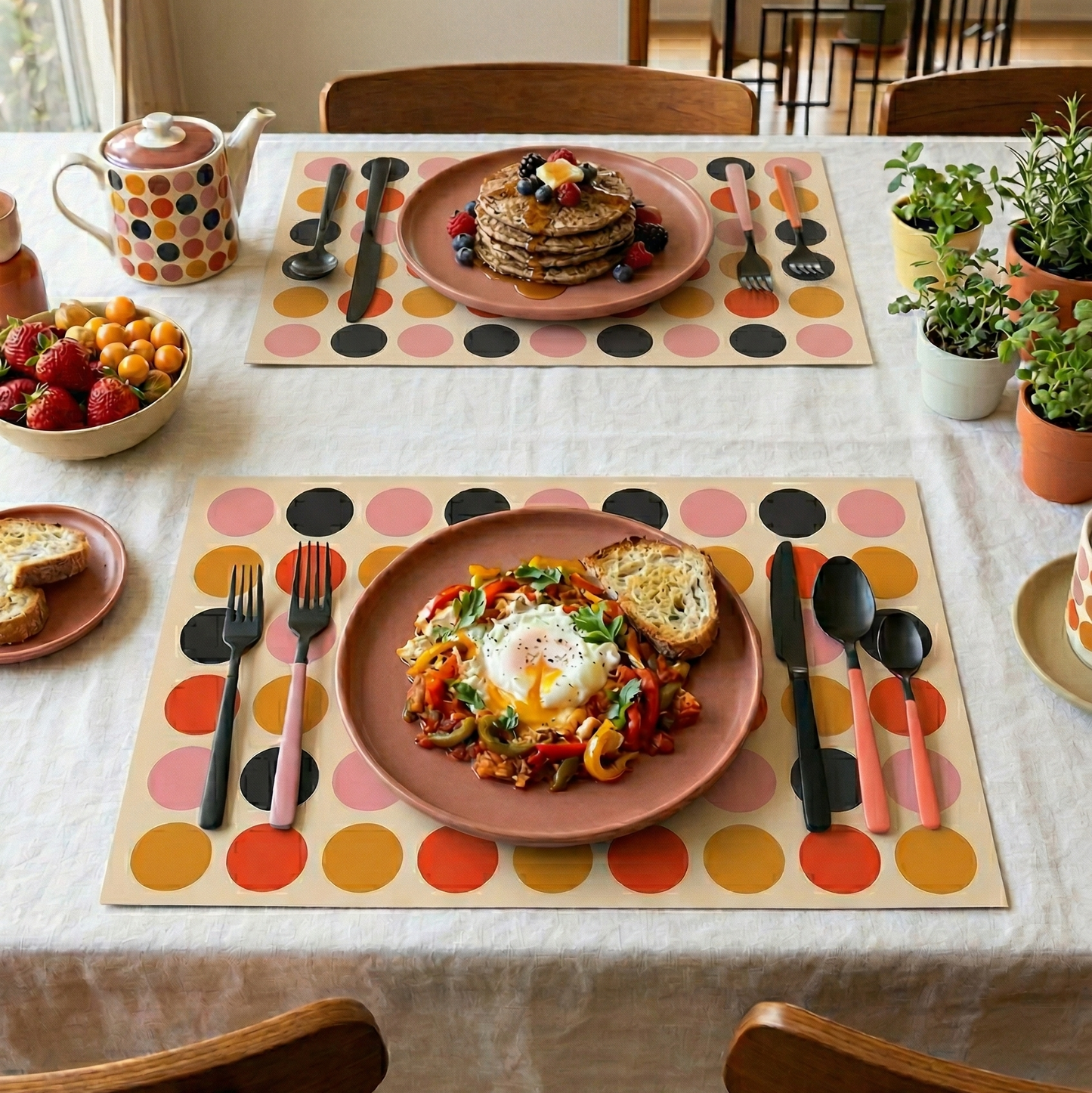 Dining table set with plates of food, cutlery, and colorful polka dot paper placemats.