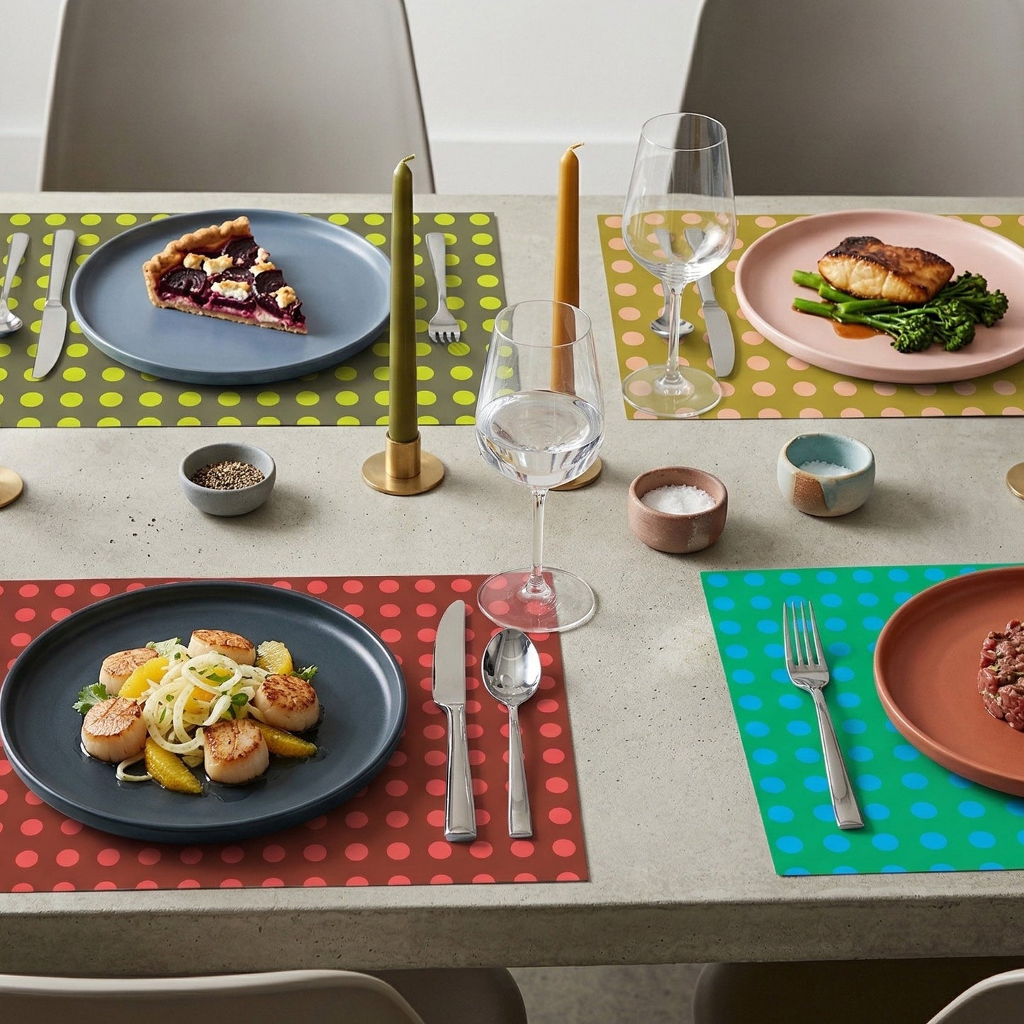 Dining table set with colorful paper placemats, plates, and cutlery.
