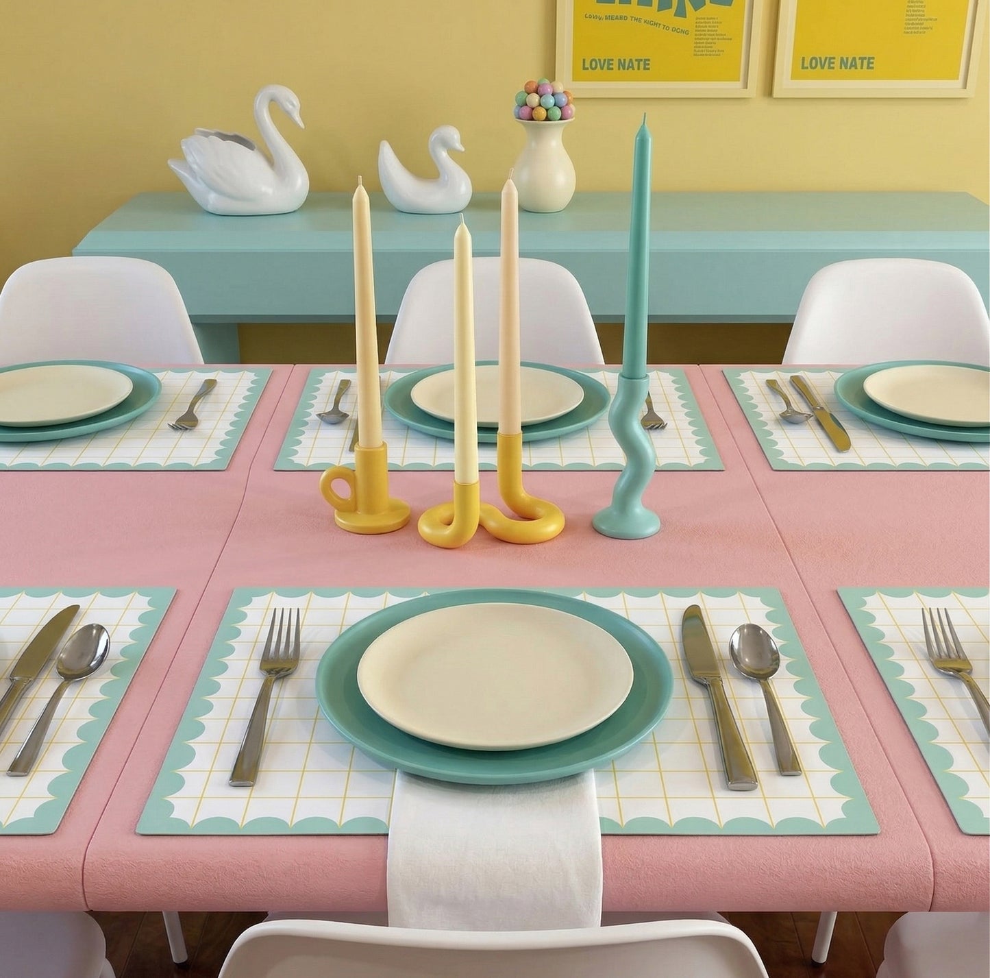 Dining table set with pastel-colored candles and place settings on colorful grid paper placemats.