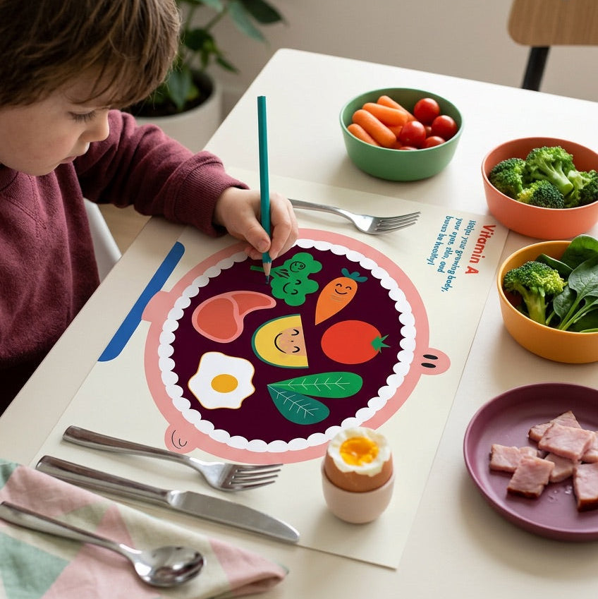 Child coloring a food-themed picture at a table with various food items and utensils.